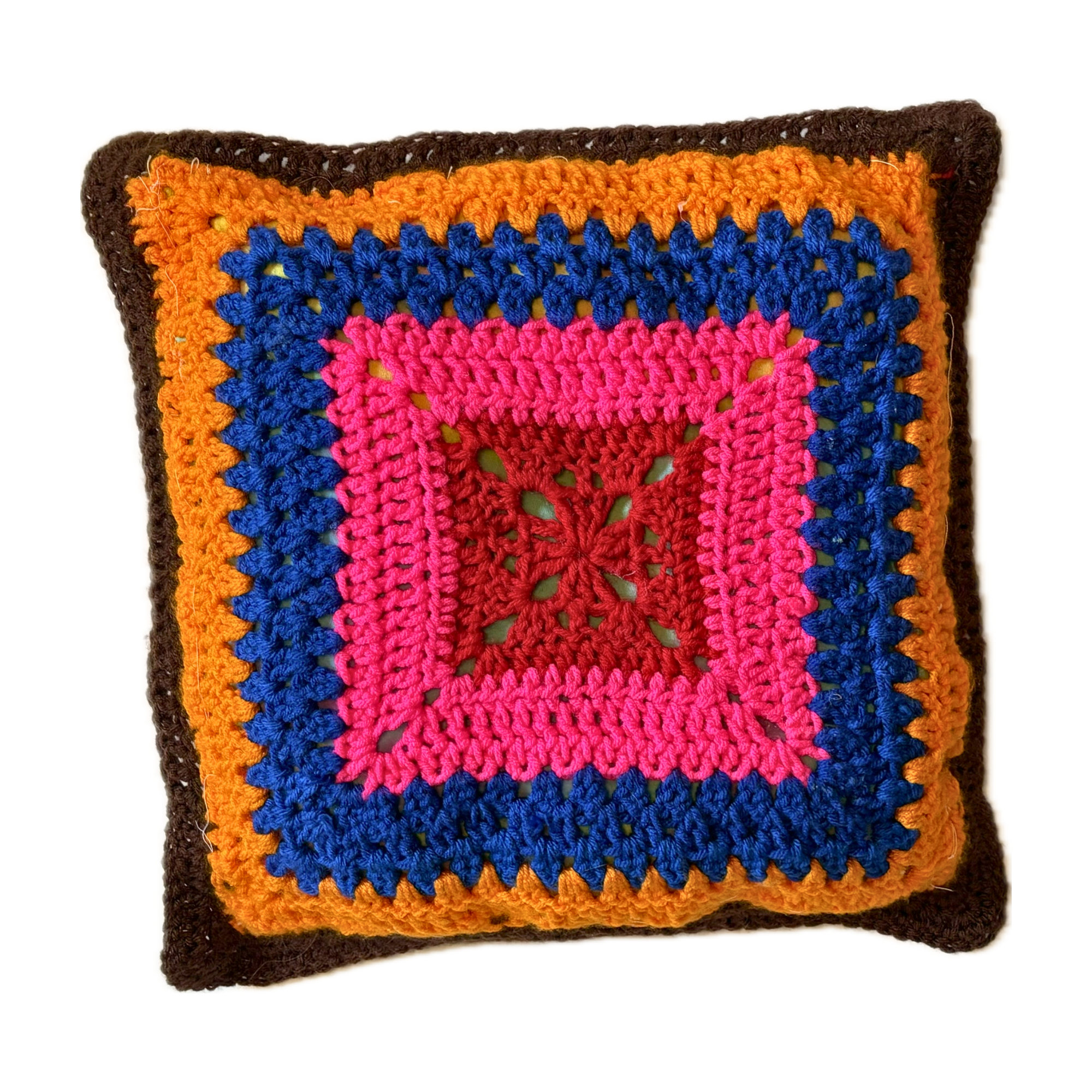 Colorful crocheted pillow with a square design on a white background