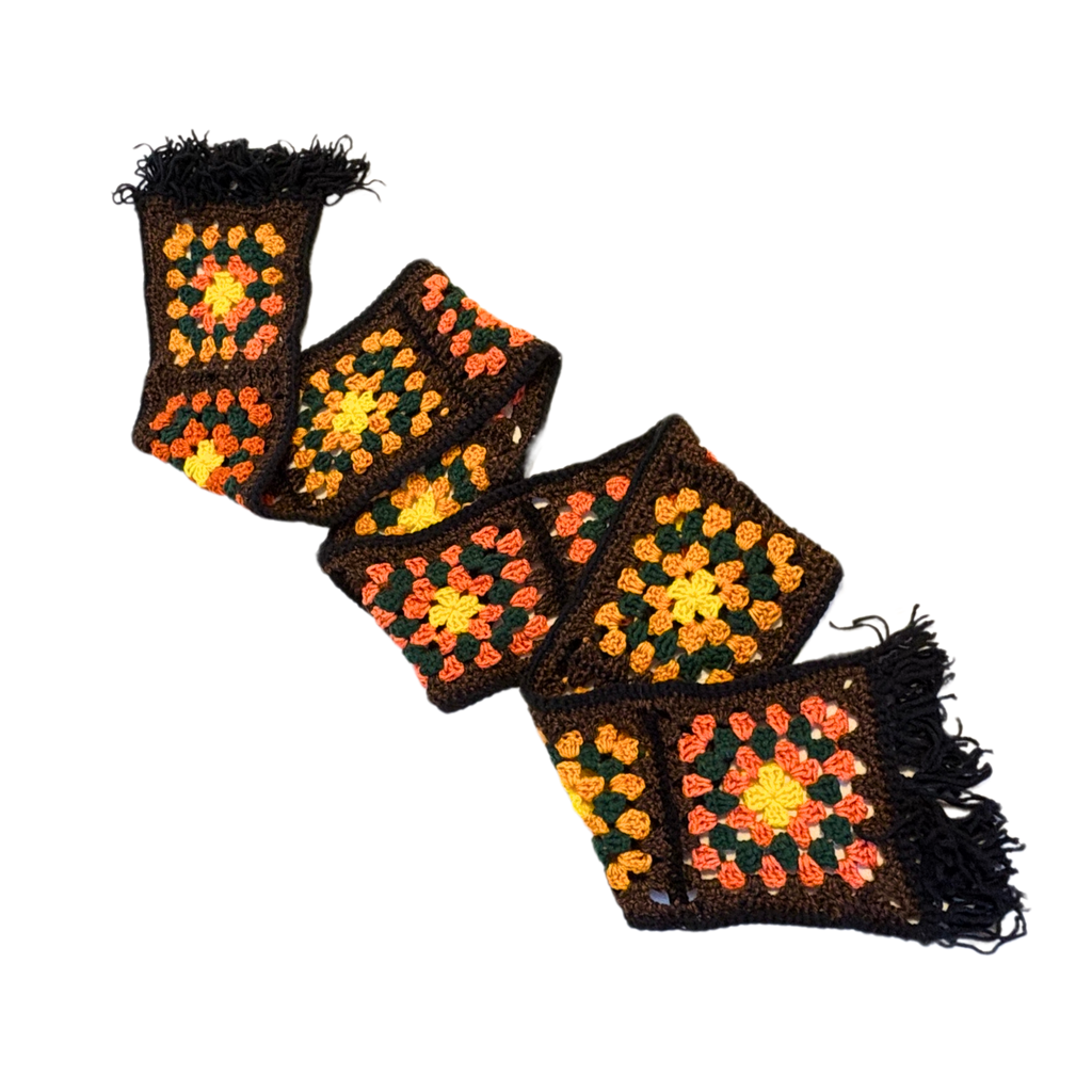 Colorful crocheted scarf with geometric pattern on a white background
