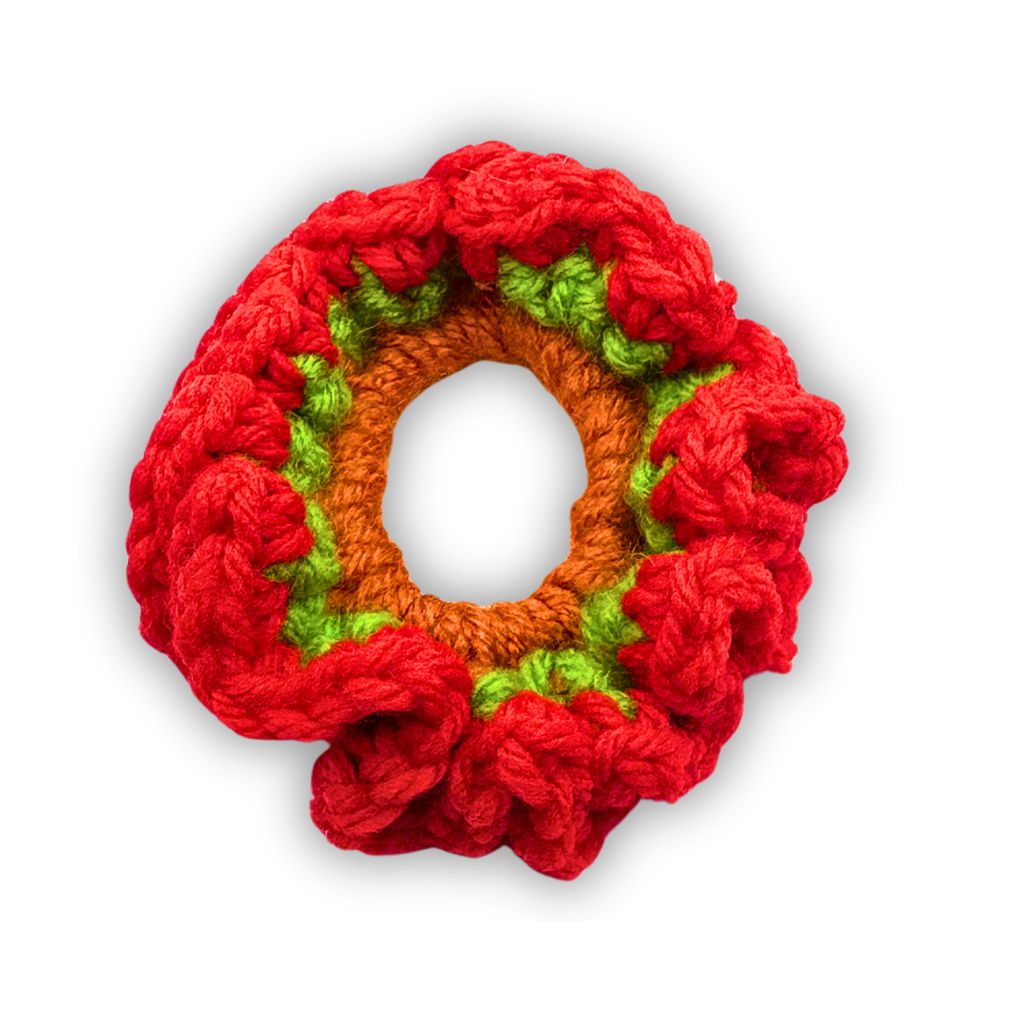Crocheted wreath with red, orange, and green colors on a white background