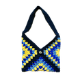 Crocheted bag with blue and yellow pattern on a white background