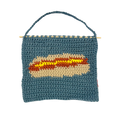 crochet hot dog pouch with mustard on a white background