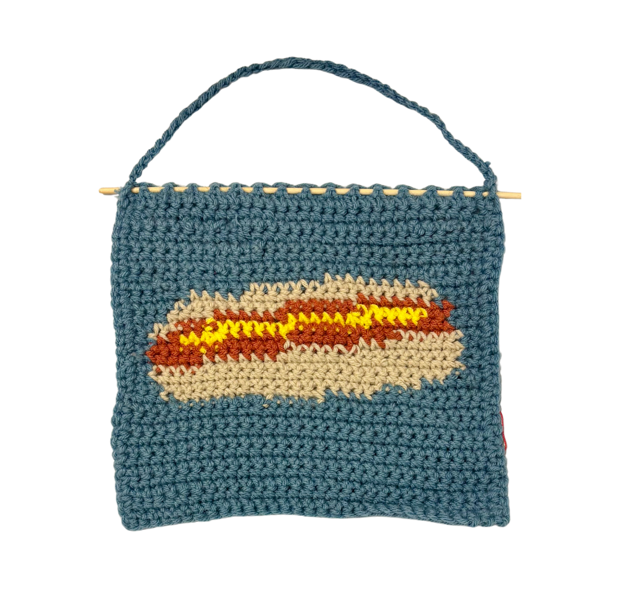 crochet hot dog pouch with mustard on a white background