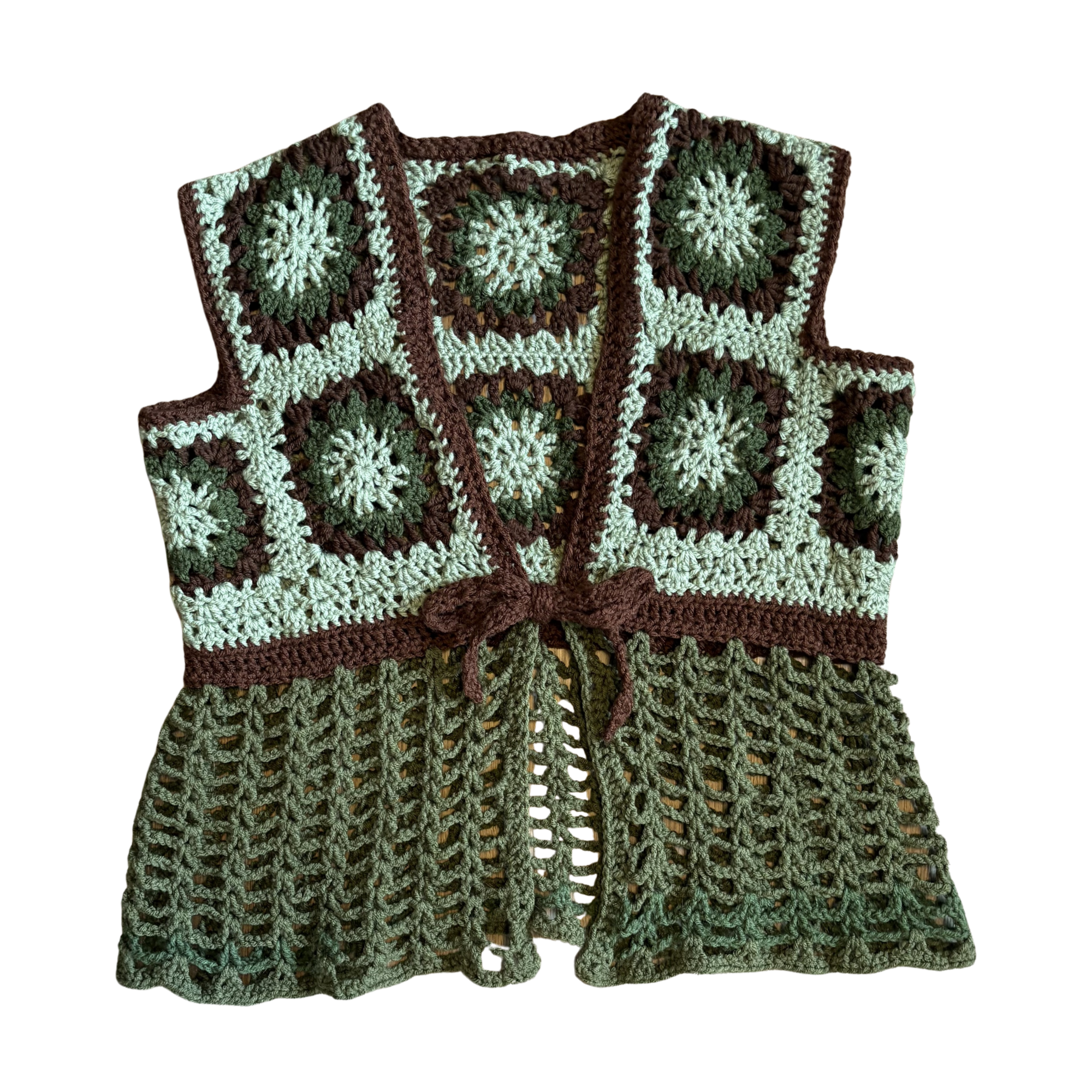 Crocheted vest with a pattern of green and brown squares on a white background