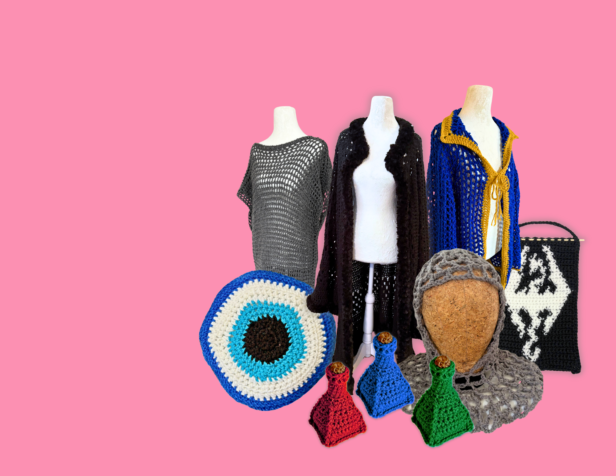 Collection of handcrafted clothing and accessories on mannequins against a pink background