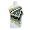 Crocheted shawl with green, black, and beige pattern on a mannequin against a white background