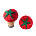 Two crocheted tomato-shaped hats with green stems on a white background